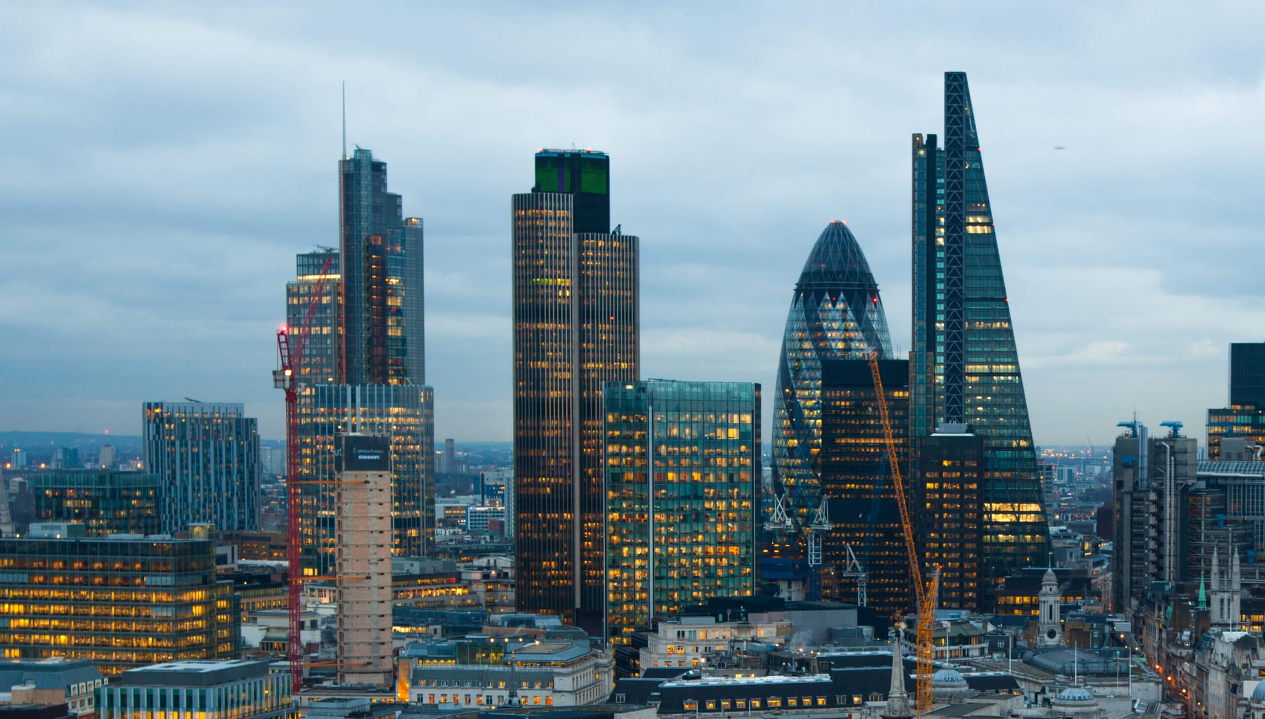 Cityscape view of central London at dusk, including the Shard and the Gherkin