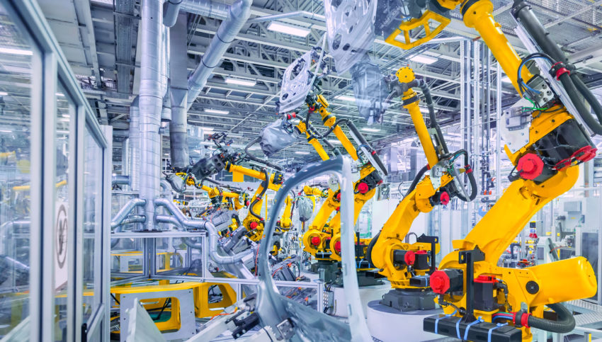 Yellow robot arms at an automotive assembly factory