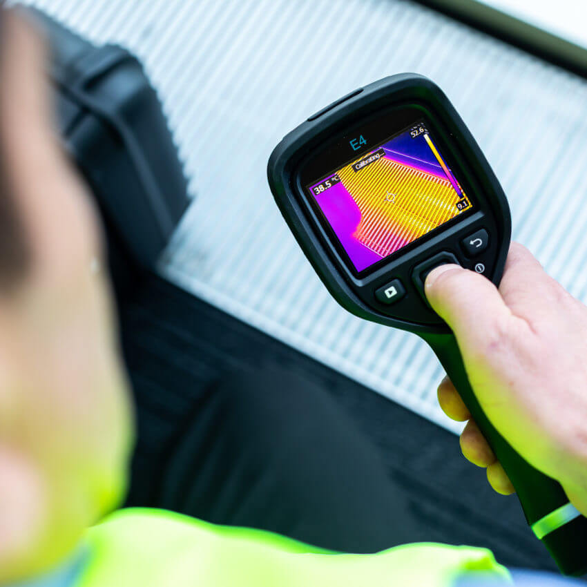 Worker using a handheld temperature sensor