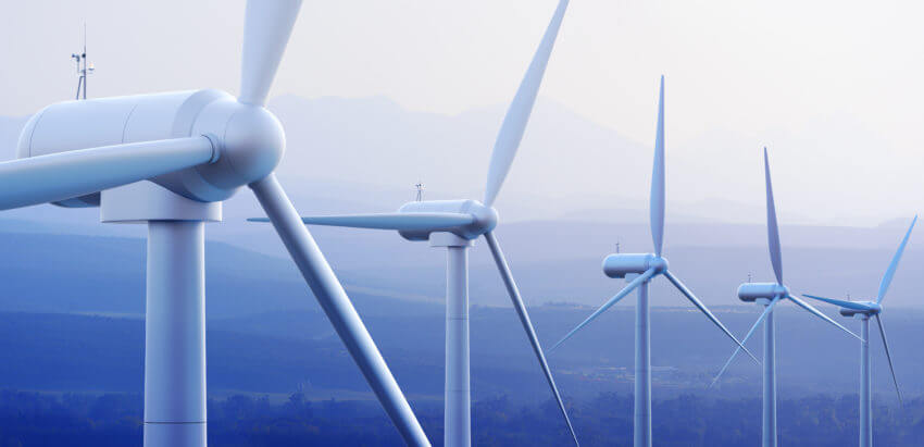 A row of white wind turbines with a sunset background