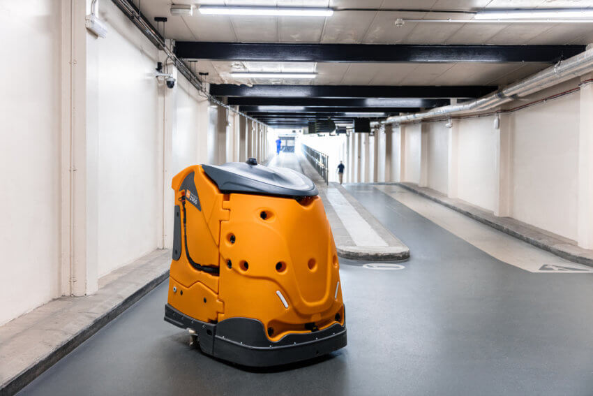 Yellow robotic cleaner patrolling a utility corridor