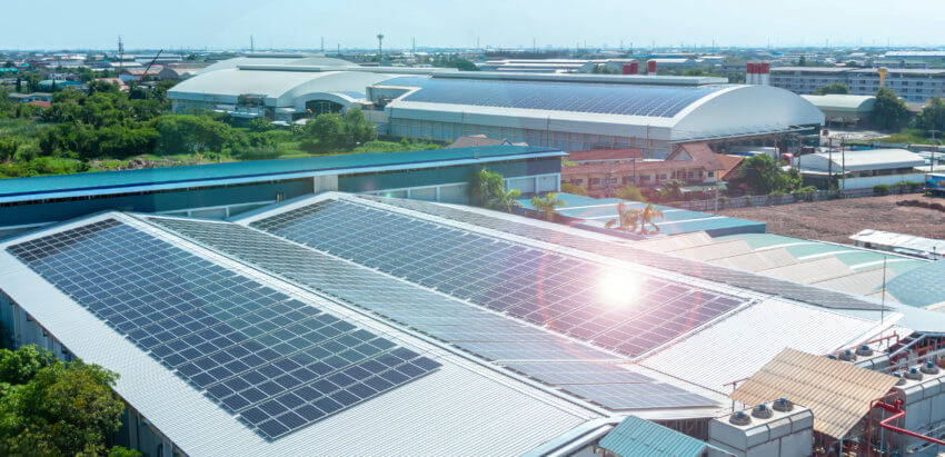 Solar panels on the roof of a building, sun shining on them