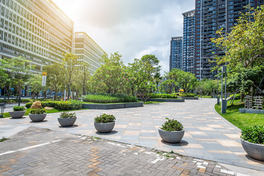 Buildings with greenery and seating area in between