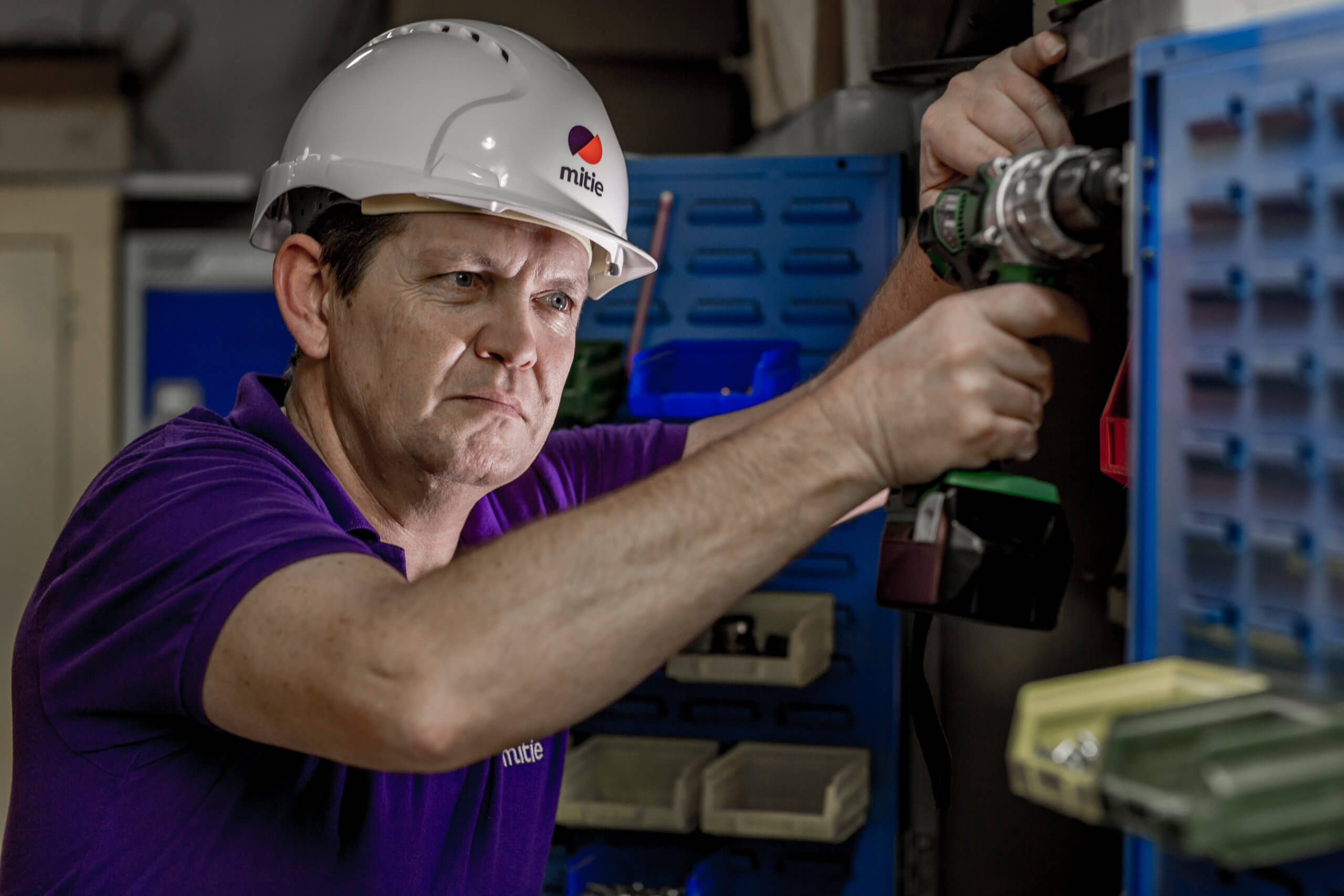 Mitie engineer operating a drill