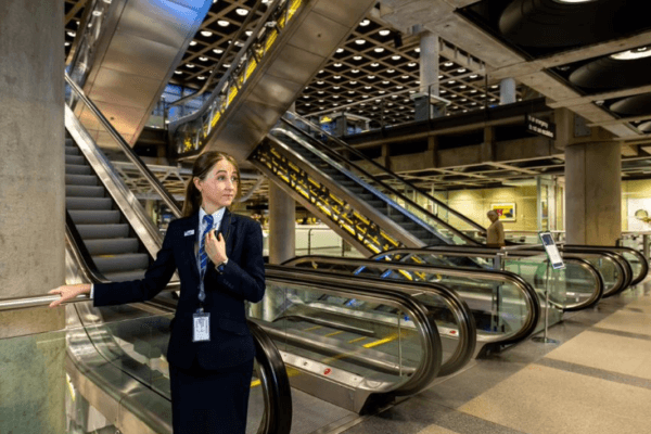 A security officer standing by an escalator