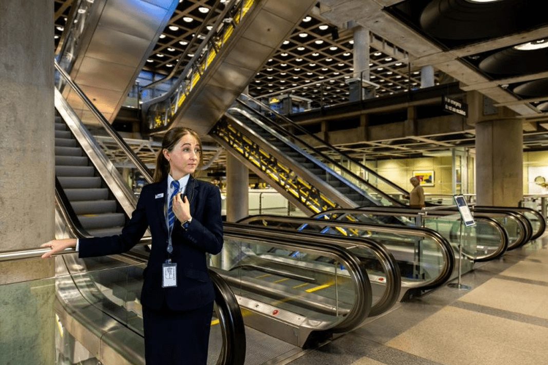 A security officer standing by an escalator