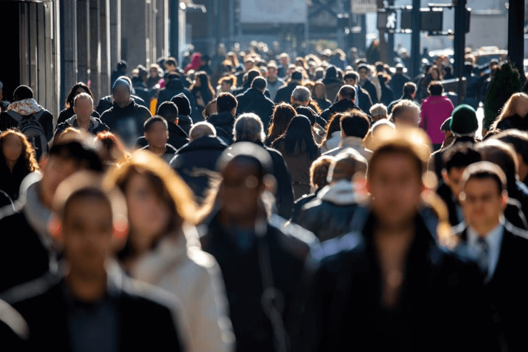 A crowd of people walking in a busy area