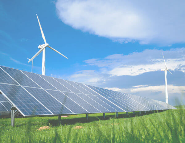 Solar energy panels and windmills against blue sky on summer day