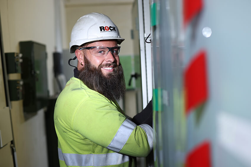 Rock Power Connection male employee, smiling and wearing high vis clothing