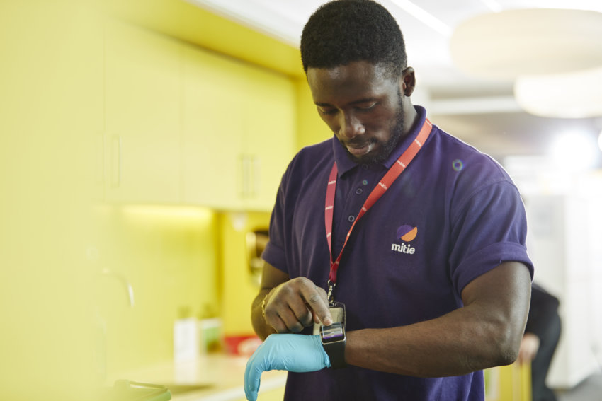 Mitie cleaning employee tapping his smart watch