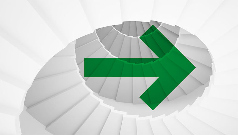 Green arrow pointing right, overlaid a spiral of white stairs