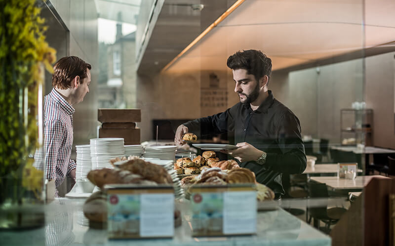 Breakfast pastries being offered at a catering buffet