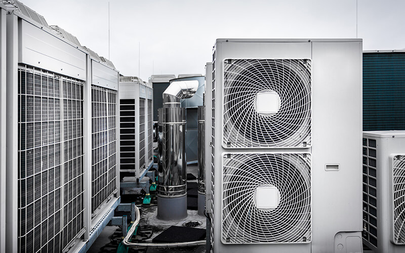 Square air-conditioning units with round fan grills on the roof