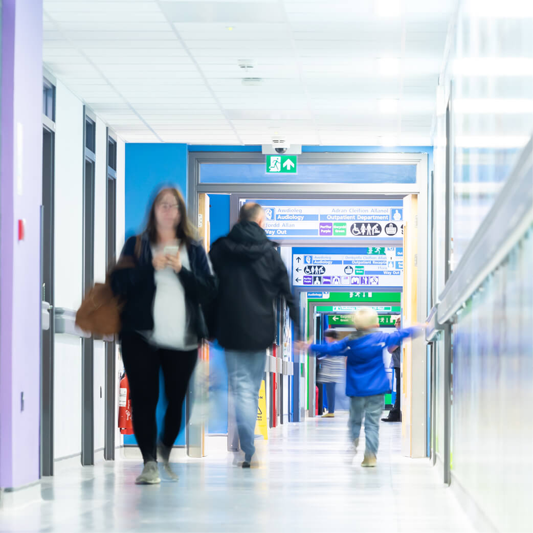 People walking down a hospital corridor, with a slight blur effect
