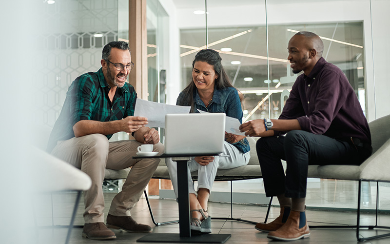 Casual meeting of smiling diverse business team analyzing financ
