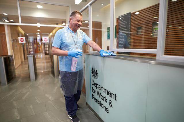 Mitie cleaner wiping a counter at the Department for Work & Pensions