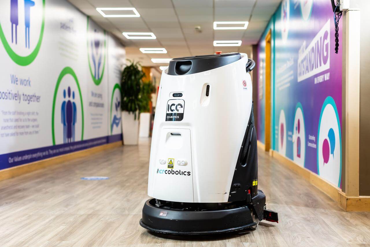 Mitie black-and-white cleaning robot in a corridor