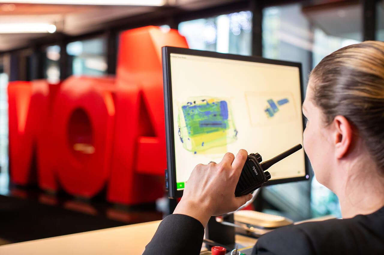 Female security guard using a walkie-talkie at Aon offices