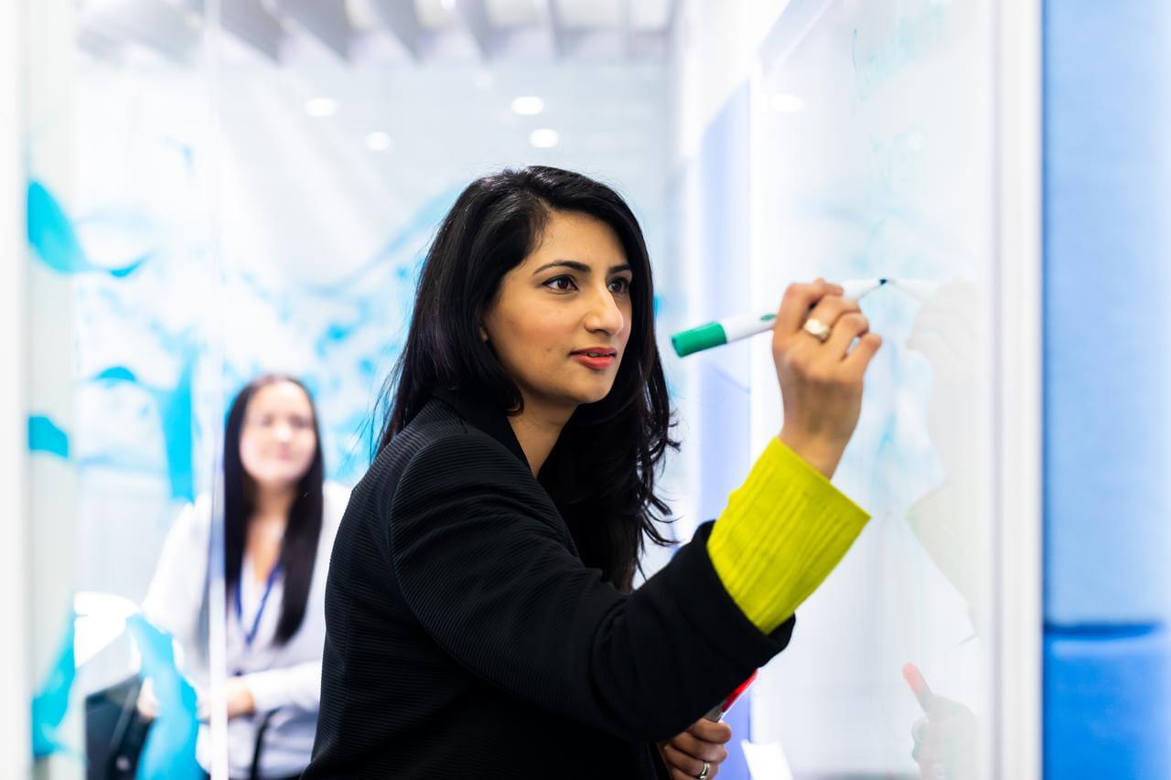 Women writing on an office whiteboard