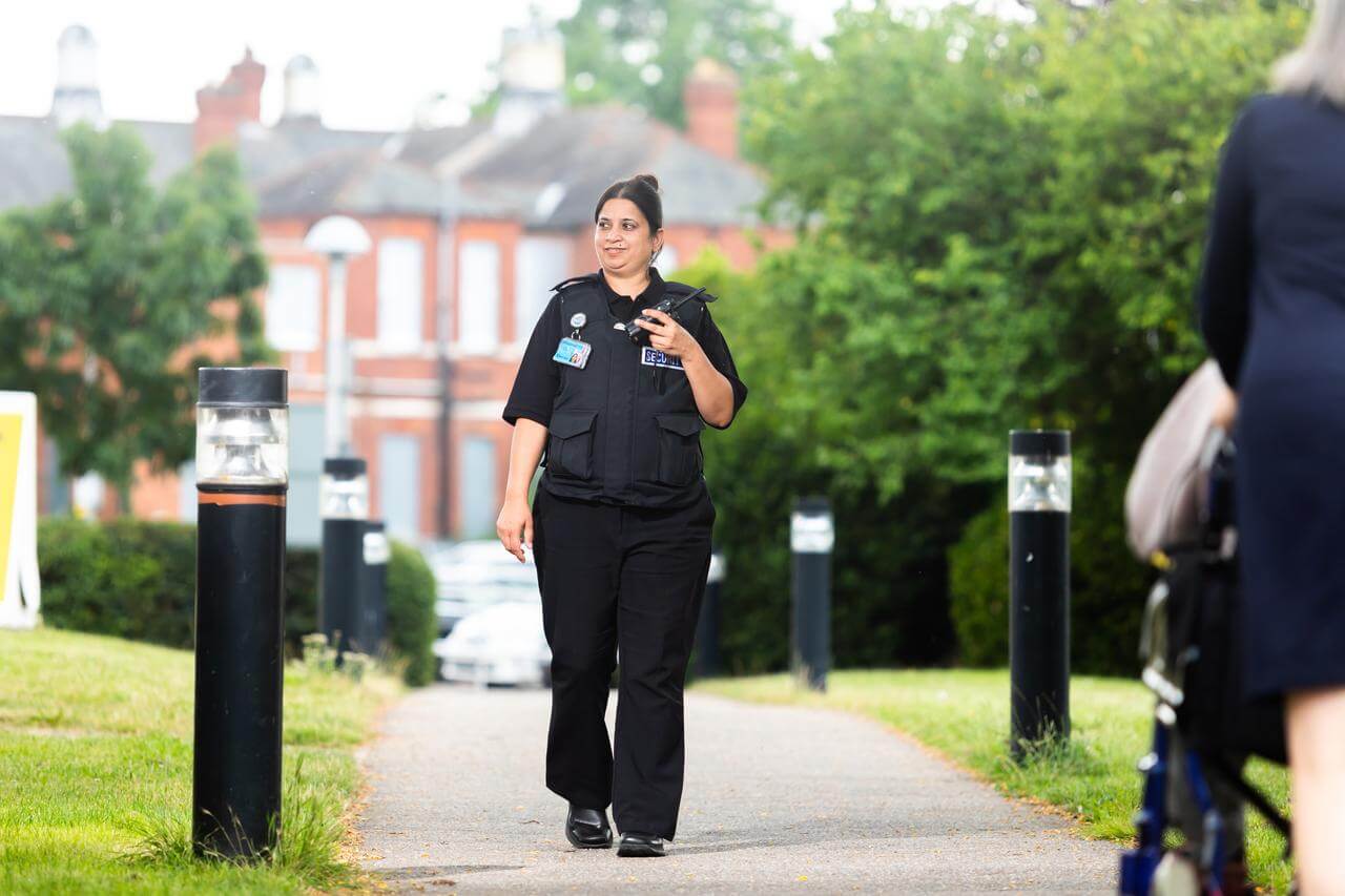 Female security guard walking through a park