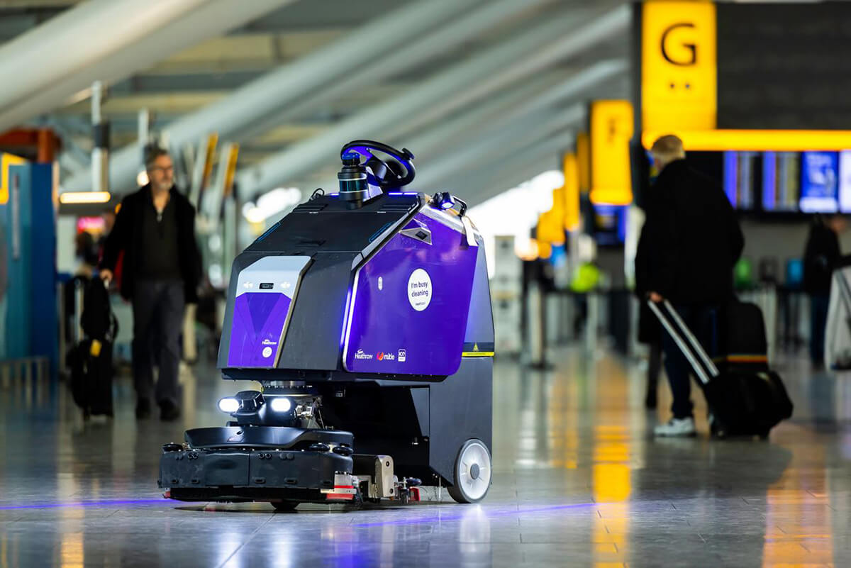 Mitie robotic cleaner, clad in purple, automatically patrolling in Heathrow Airport