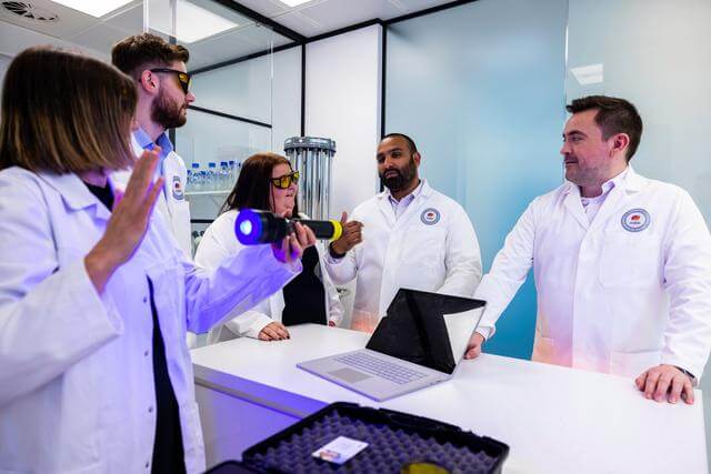 Mitie staff in a lab environment demonstrating UV cleaning techniques