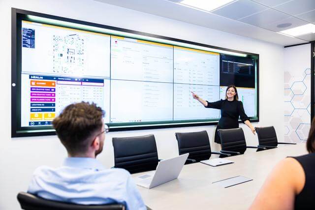 Professional woman pointing at a presentation screen in a boardroom