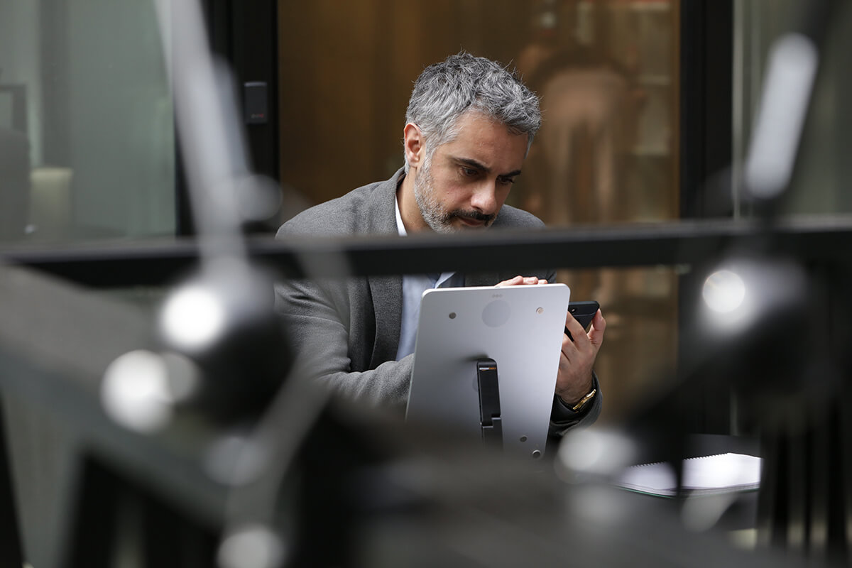 Man in a grey suit using a tablet while looking worried