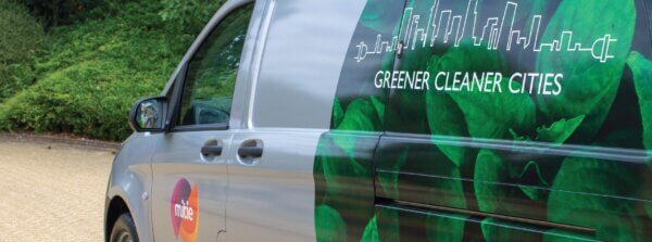 A close-up of a Mitie van, with 'Green Cleaner Cities' decal design on the side