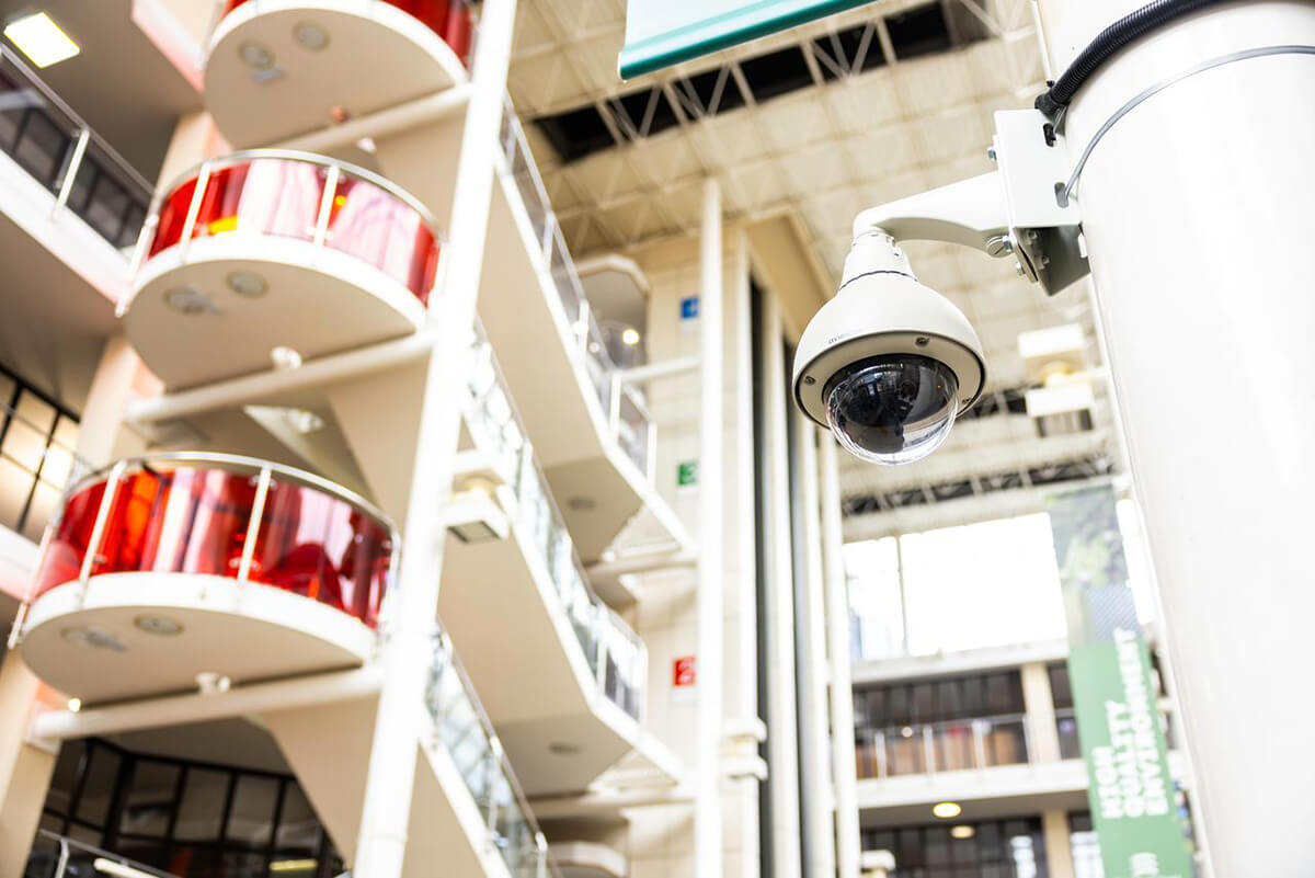 Looking up at a security CCTV camera on a column in a shopping centre