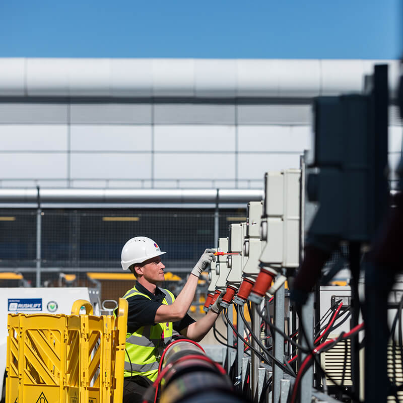 Mitie male engineer using a screwdriver on electrical wiring at Heathrow airport