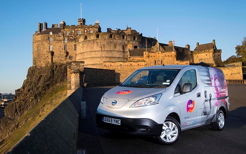 EV silver van with Mitie branding in the foreground, with Edinburgh Castle in the background