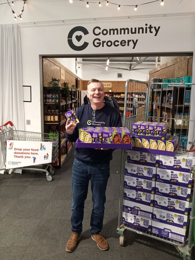 A man holding a pallet of Easter eggs at the Community Grocer in Manchester