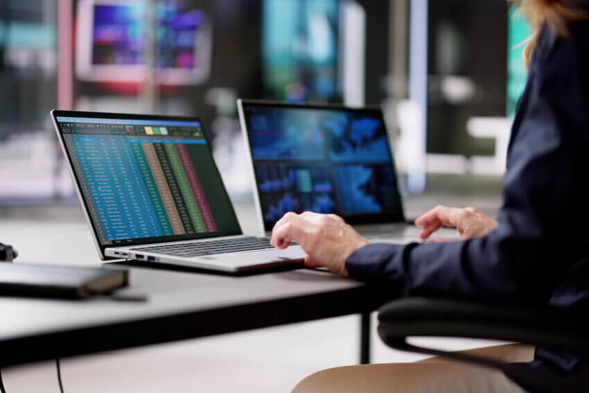 An office worker looking at financial charts on a laptop