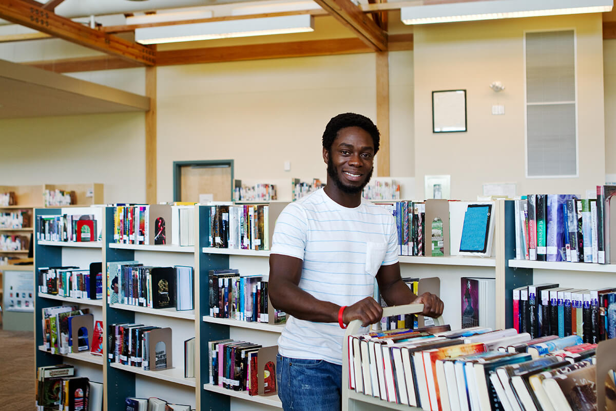 Man pushing the book cart in a prison library