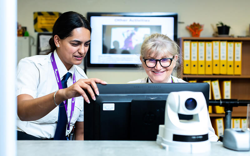 Two smiling Care and Custody receptionists