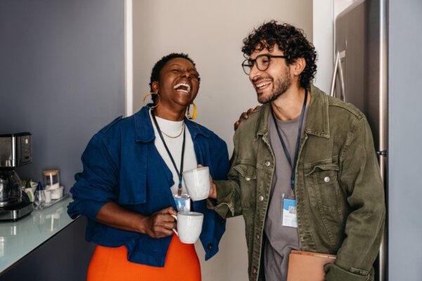 Two colleagues laughing over coffee
