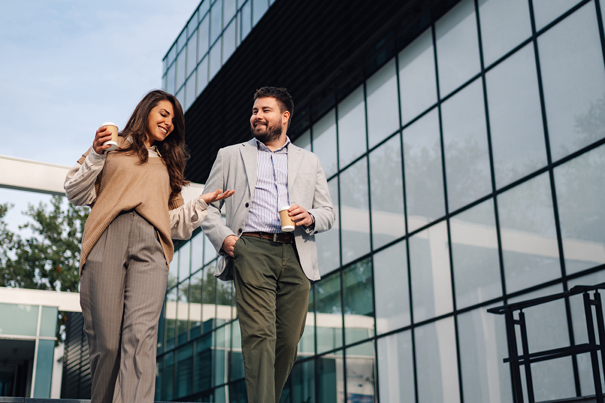 Two workers outside a glass office building