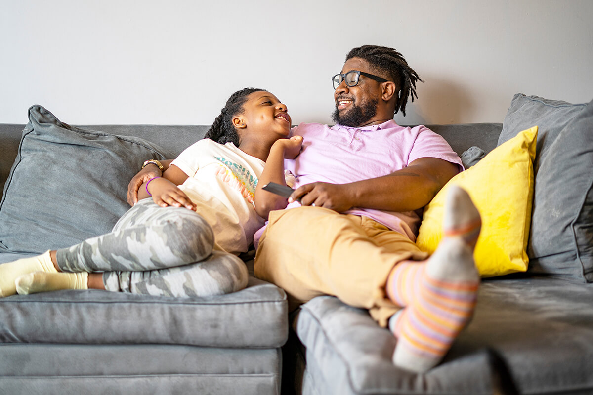 Father and daughter sitting on sofa