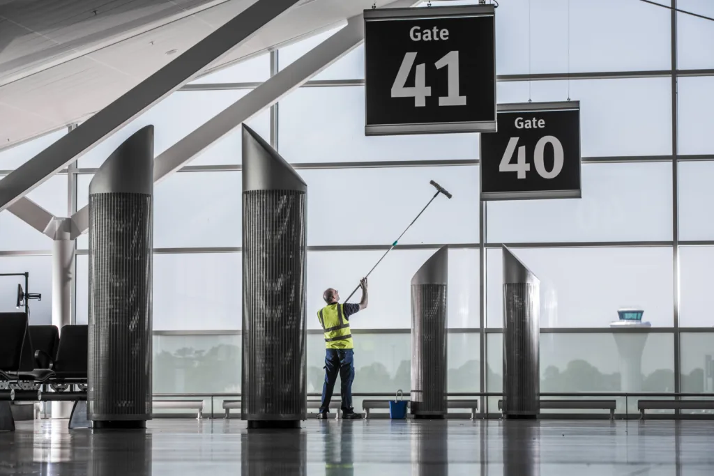 Mitie colleague cleaning glass at Birmingham Airport