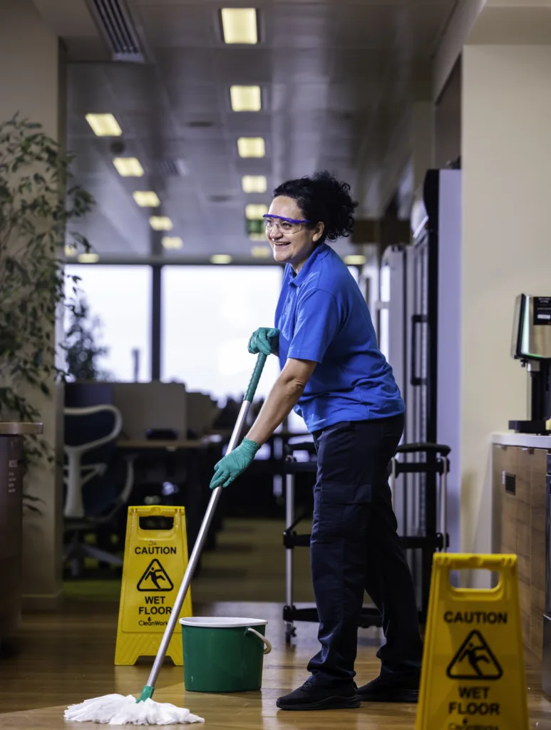 A Mitie cleaner mopping an office floor