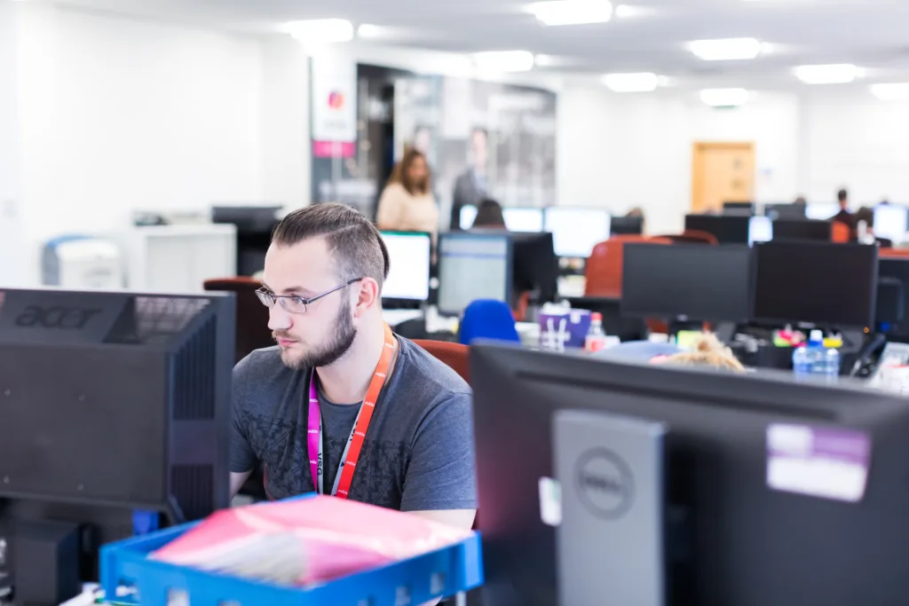 Mitie Intelligence colleague at Mitie Intelligence Hub looking at monitors