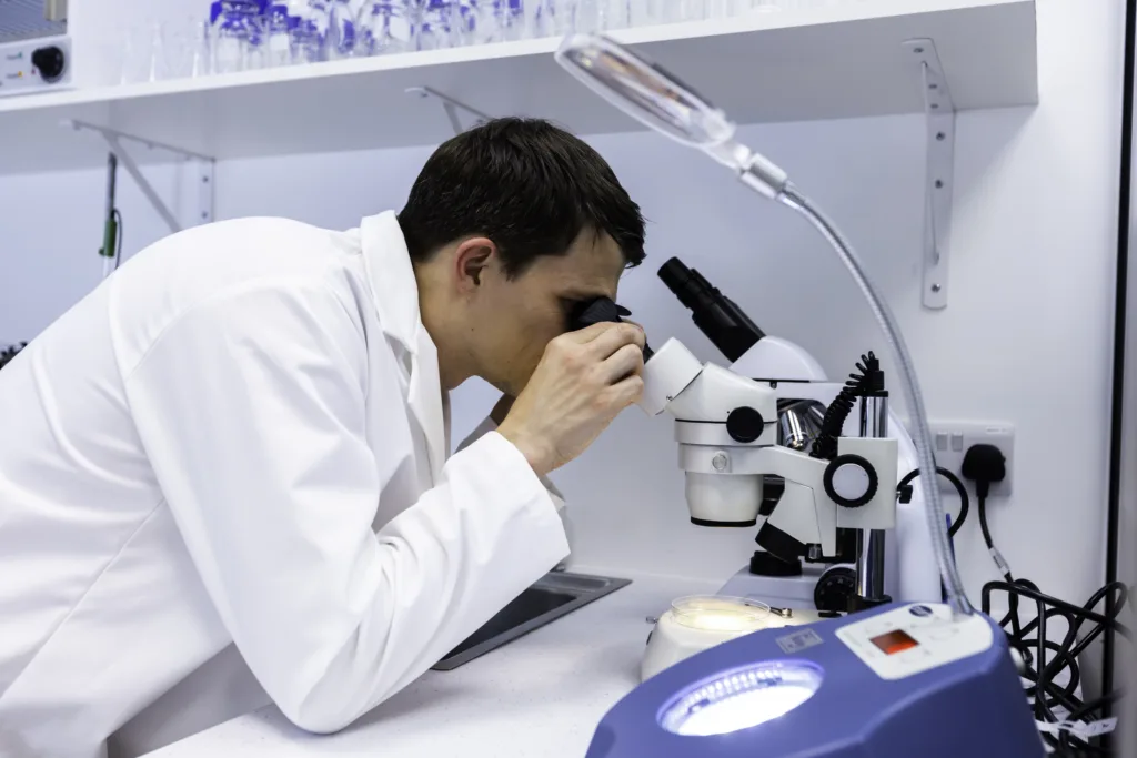 Lab worker using a microscope