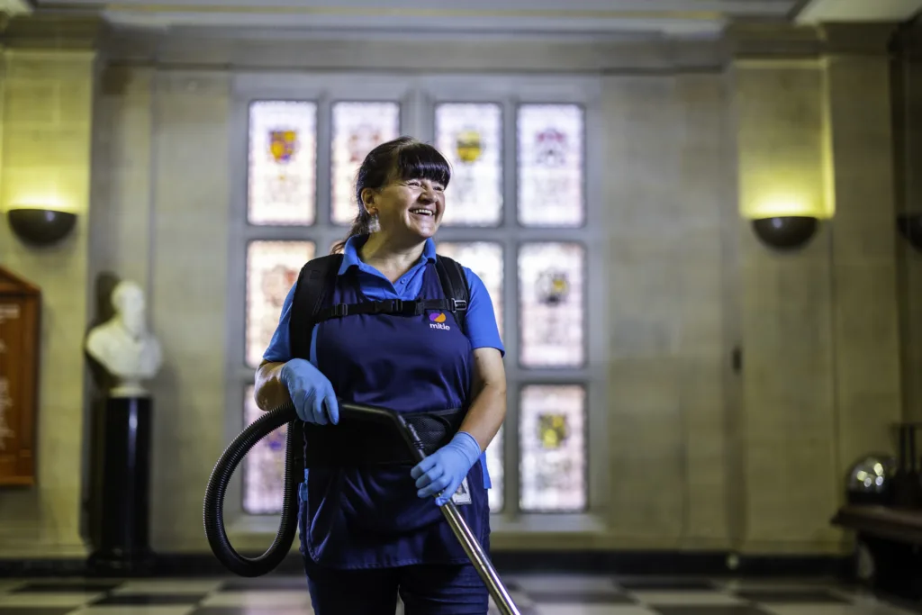 Mitie cleaner in front of stained glass windows