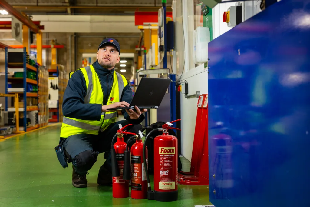 Mitie colleague inspecting fire extinguishers