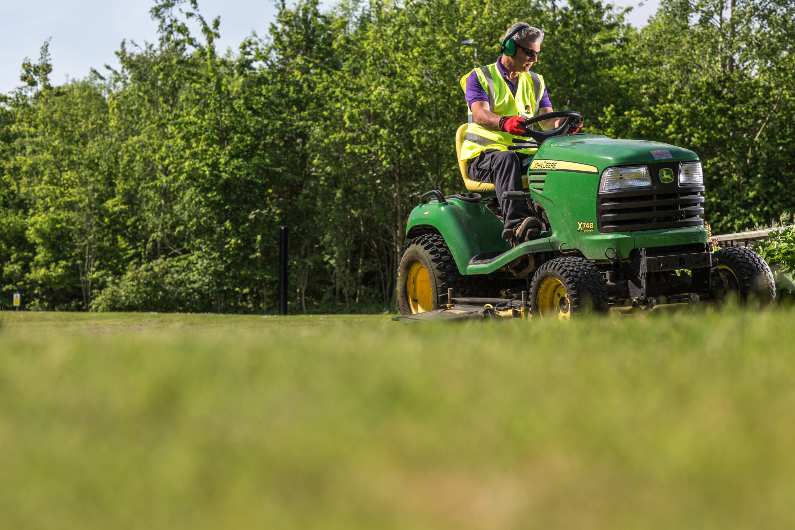 Mitie landscape colleague riding a lawnmower
