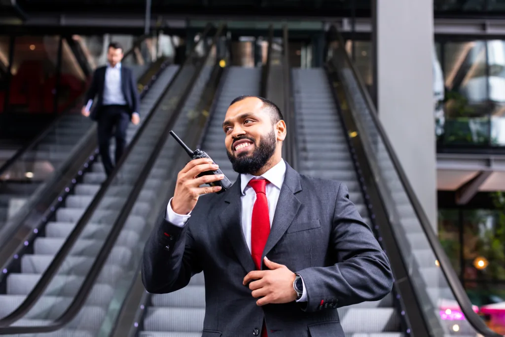 Mitie security guard in front of escalators