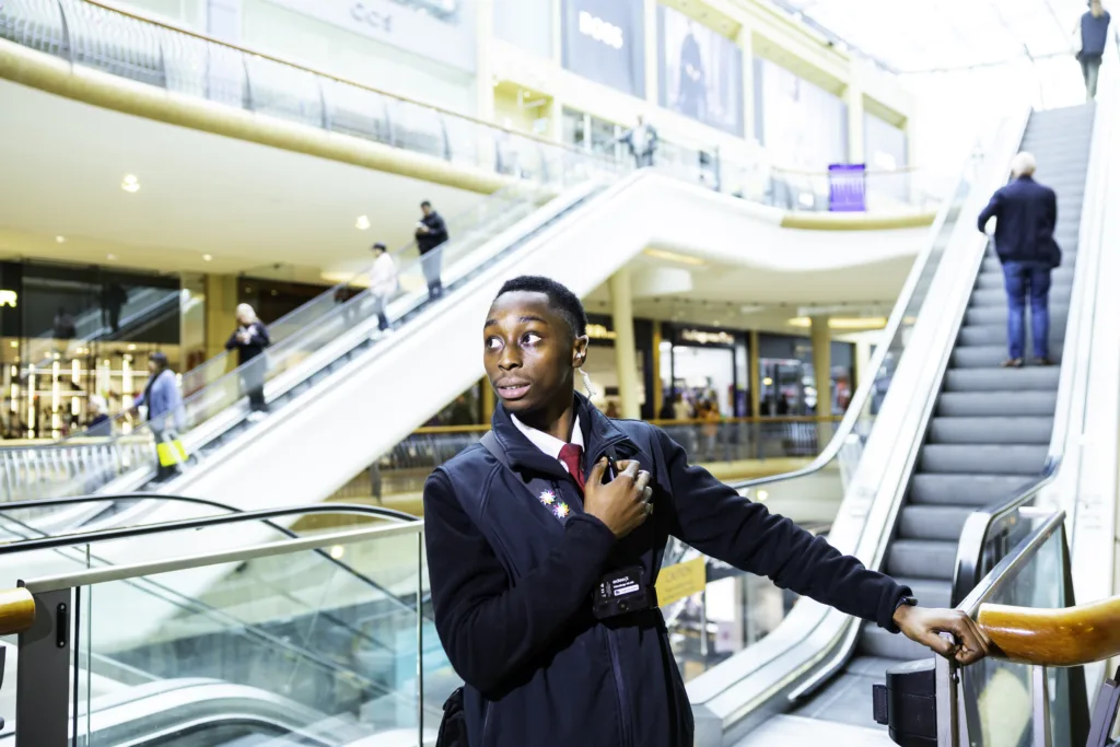 Mitie security guard by an escalator