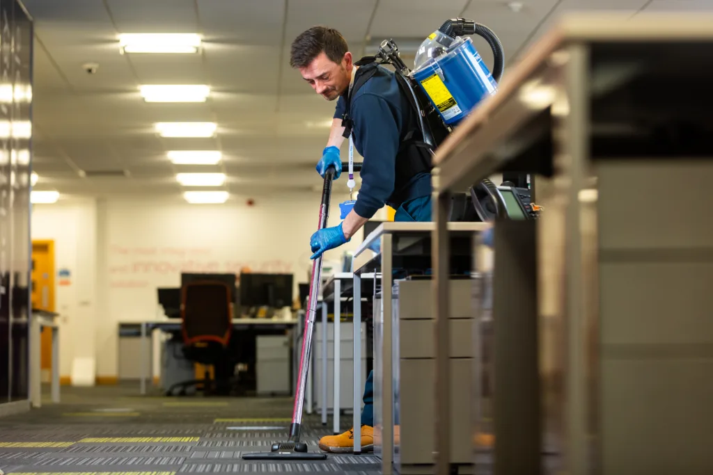 Mitie cleaner vacuuming an office