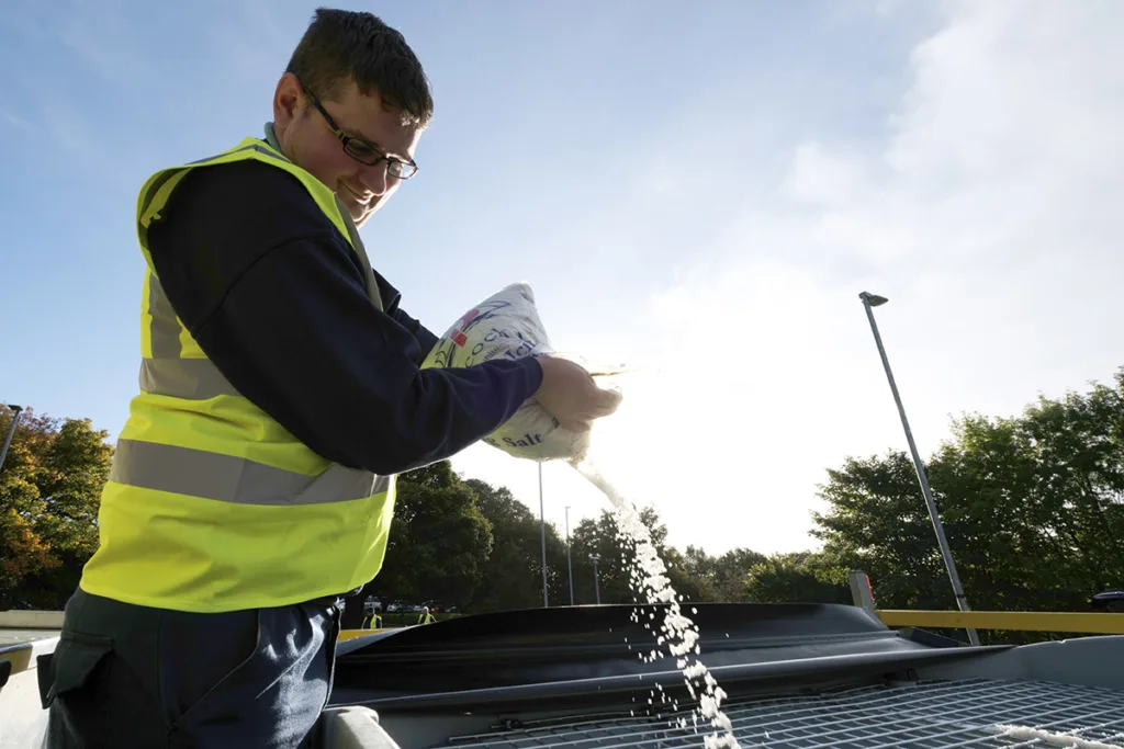 Mitie colleague adding salt to a winter gritting machine